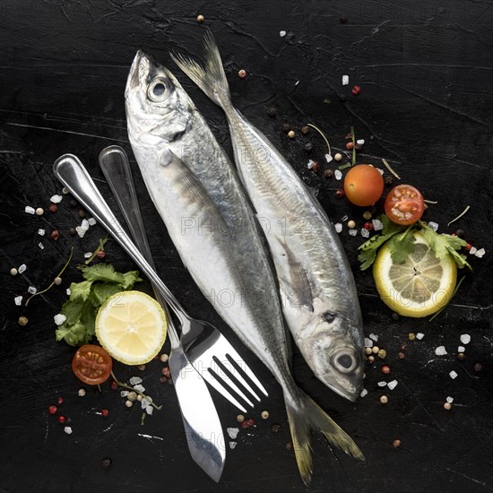 Flat lay fish with tomatoes cutlery