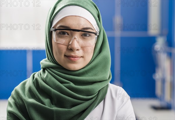 Front view female scientist with hijab posing laboratory