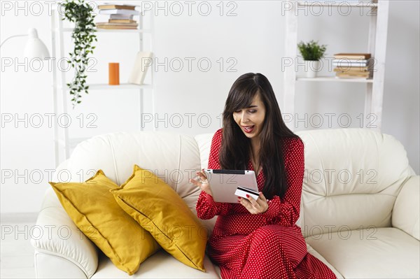 Front view woman home ordering items sale using tablet credit card