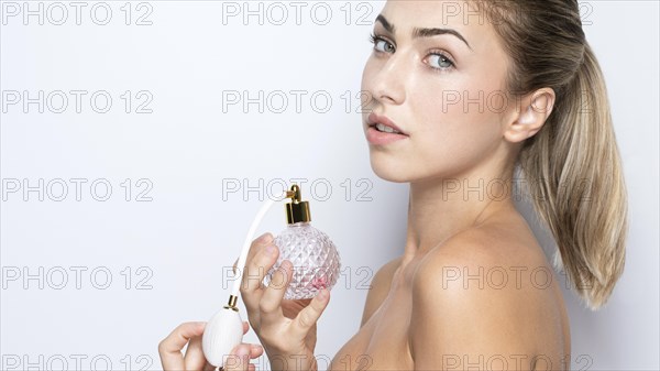 Front view woman with perfume bottle