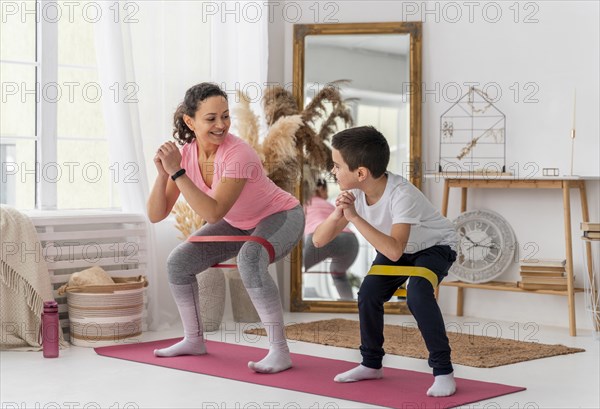 Full shot woman kid training with resistance band