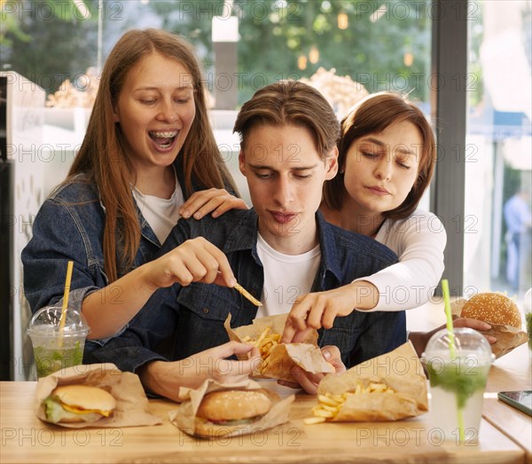 Group friends fast food restaurant eating burgers