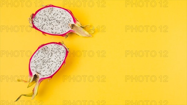 Halved dragon fruit yellow background