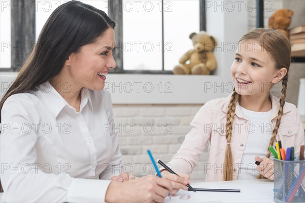 Happy female psychologist girl drawing with colored pencil felt tip pens paper