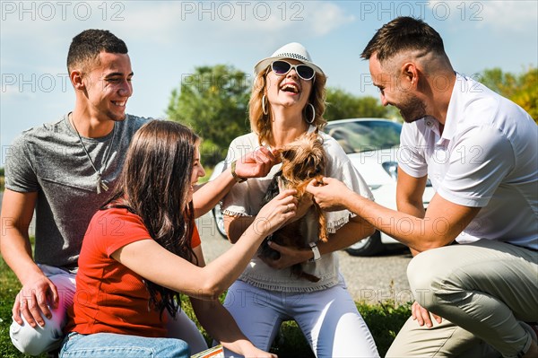 Happy friends with cute dog outdoors