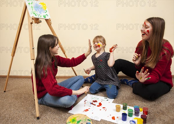 Happy girl with down syndrome woman painting