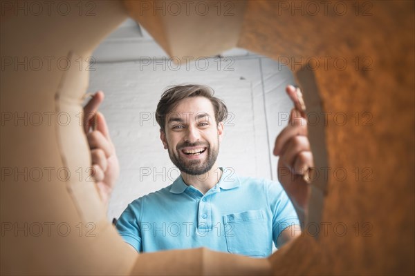 Happy man looking inside paper bag