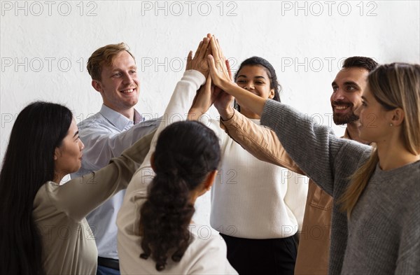 Happy people high fiving each other group therapy session