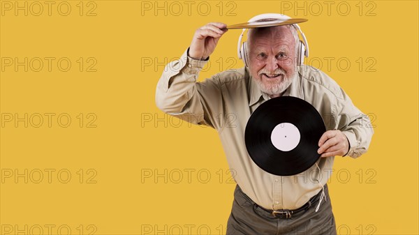 Happy senior playing with music records