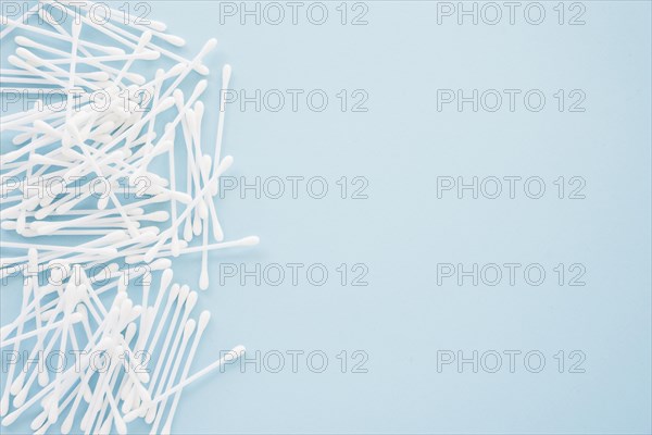 Heap cotton swabs blue background