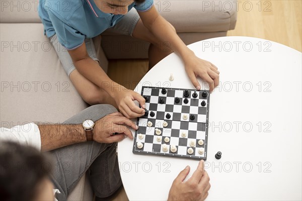 High angle father child playing chess