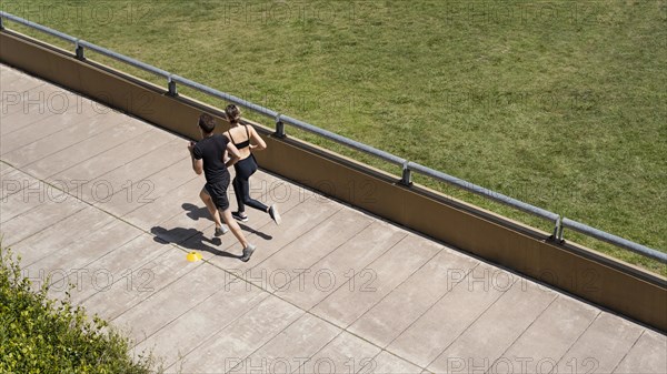 High angle man woman jogging together outside