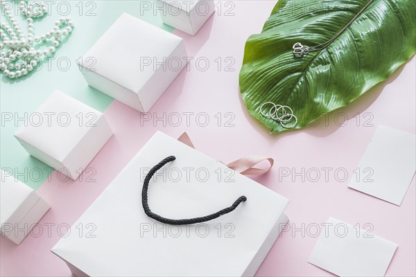 Jewelry with white boxes leaf paper backdrop