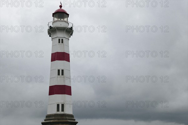 Lighthouse against dark overcast sky