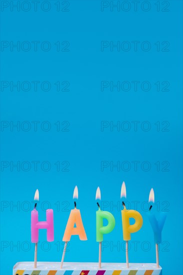 Lit colorful candles with blue background