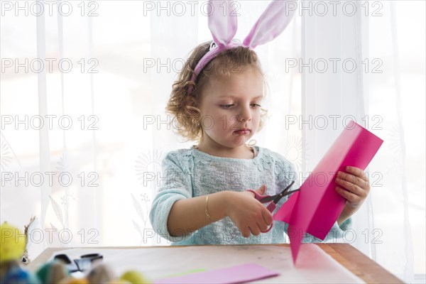 Lovely girl cutting easter decorations