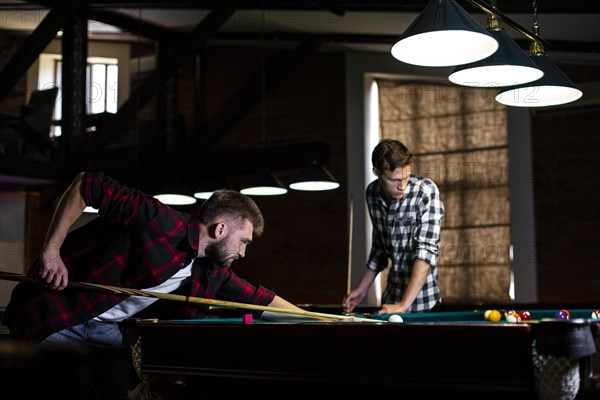 Low angle guys playing billiard club