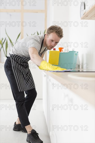 Low angle man cleaning kitchen