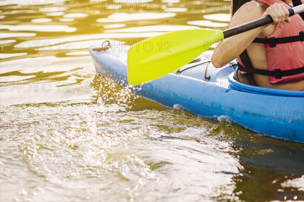 Male kayaking with paddle lake