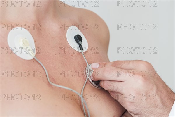 Man hand with stethoscope checking respiration woman