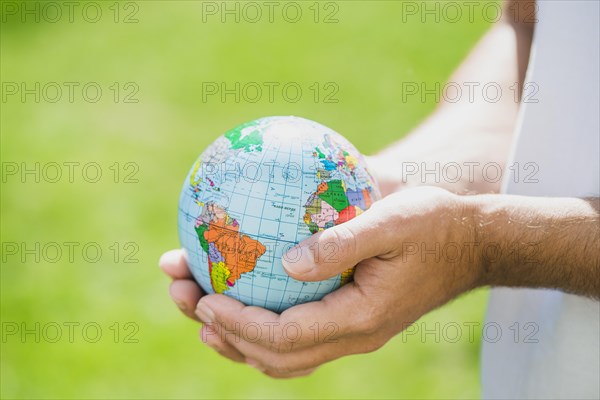 Man s hand holding small globe