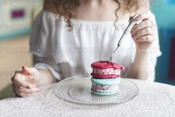 Midsection woman eating ice cream sandwich with fork