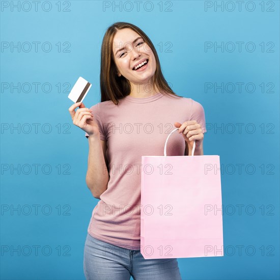 Mid shot woman holding credit card bag