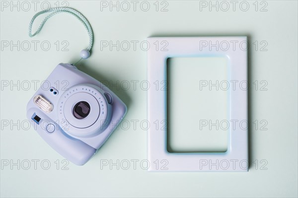 Mini instant camera empty border frame blue background