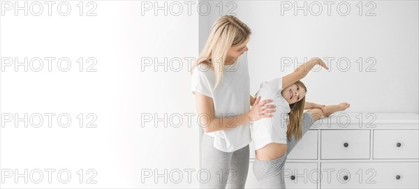 Mom helping daughter stretch