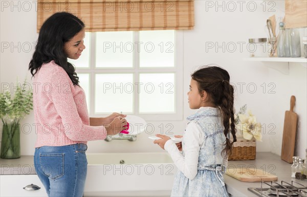 Mother daughter washing dishes