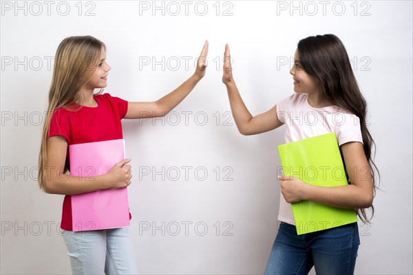 Multiethnic schoolgirls giving high five