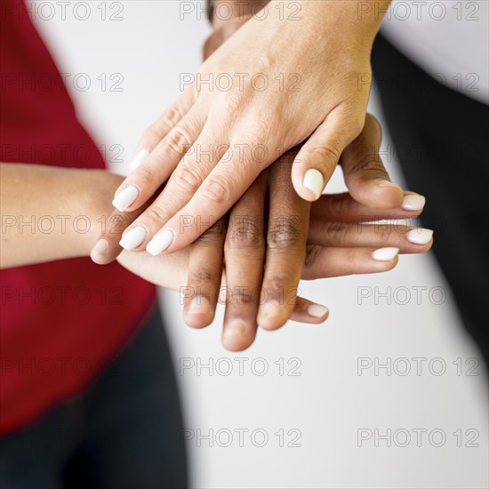 Multiracial people putting their hands together