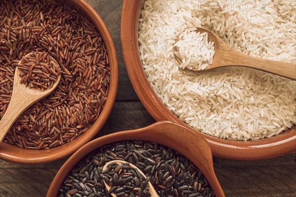 Overhead view organic rice grains with wooden spoon