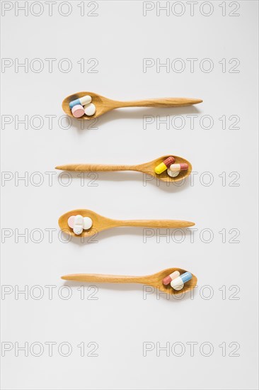 Overhead view wooden spoons with pills