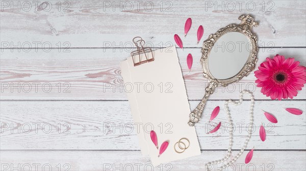 Papers with petals near flower rings mirror