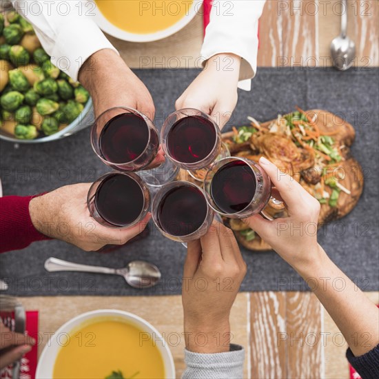 People clanging wine glasses festive table