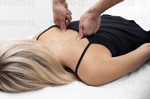 Physiotherapist performing back massage female patient