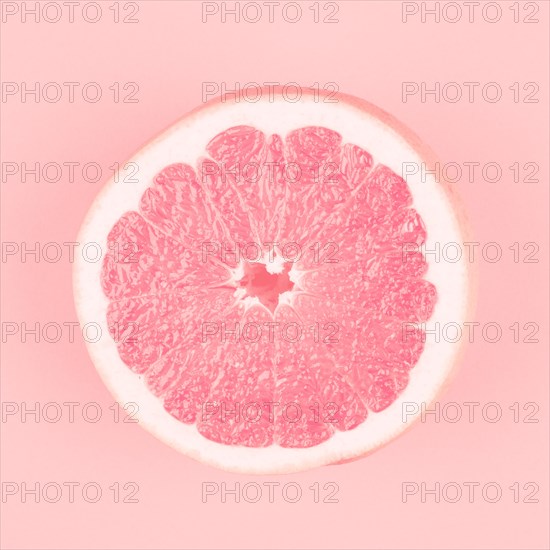 Pink halved fresh juicy grapefruit pink background