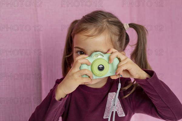 Portrait little girl playing with camera