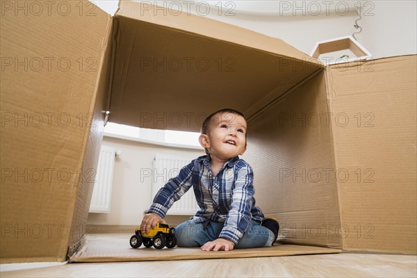 Portrait smiling toddler boy playing with toy vehicles