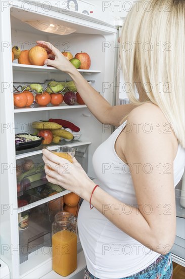 Pregnant woman looking into fridge
