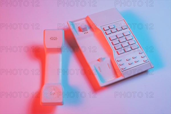Receiver landline telephone pink background with blue shadow