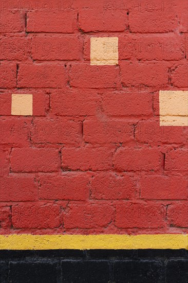 Red brick wall with yellow spots