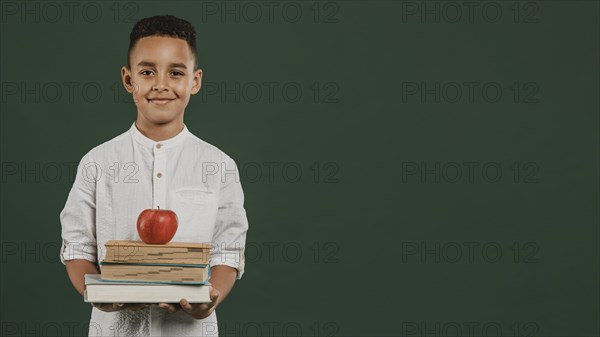 School boy holding books apple
