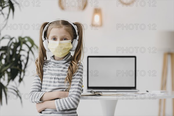 School girl wearing medical mask indoors