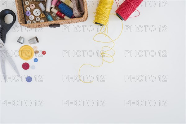 Scissor buttons thimble red yellow yarn isolated white background