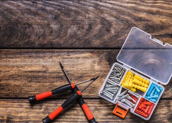 Screwdrivers with bolt kit wooden background