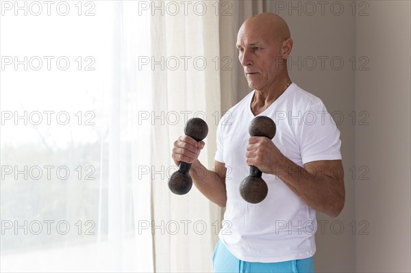 Senior man using fitness dumbbells