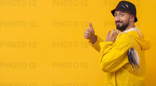 Side view fisherman with catch giving thumbs up