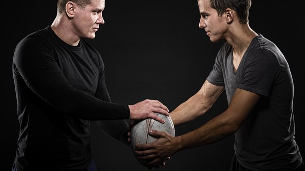 Side view male rugby players holding ball